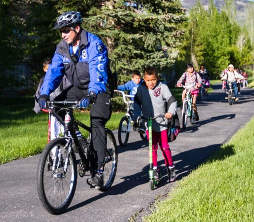 police biking with kids in a greenway