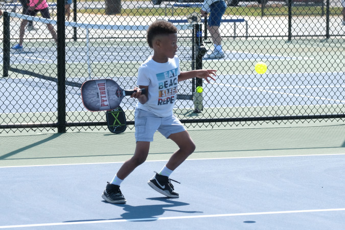 young boy playing pickleball