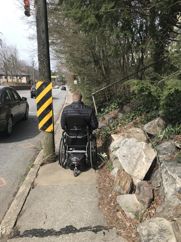 Individual using a mobility device on Charlotte Street in Asheville